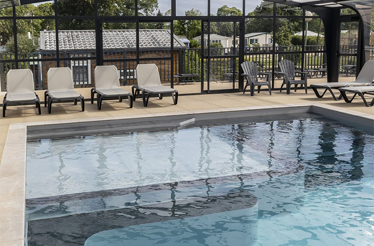 Indoor and heated swimming pool with paddling pool and spa benches, at the À l’Abri de l’Océan campsite in Brittany
