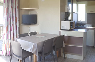 Pièce de vie avec télévision du chalet 2 chambres 5 personnes, en location au camping à l’Abri de l’Océan dans le Finistère
