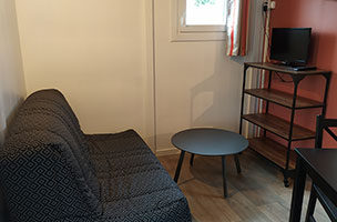 Pièce de vie du chalet confort 1 chambre 2 personnes, en location au camping à l’Abri de l’Océan dans le Finistère