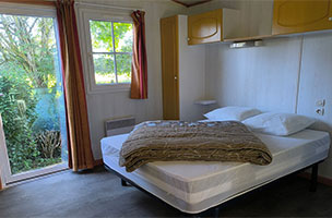 Chambre du chalet PMR 2 chambres 4 personnes. Location vacances au camping à l’Abri de l’Océan dans le Finistère à Baye