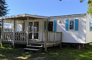 Vue du mobil-home standard 2 chambres 4 personnes avec terrasse semi-couverte en location au camping à l’Abri de l’Océan en Bretagne sud