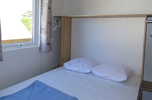 Chambre avec lit deux places du bungalow Tithome 2 chambres 5 personnes, en location au camping à l’Abri de l’Océan en Bretagne