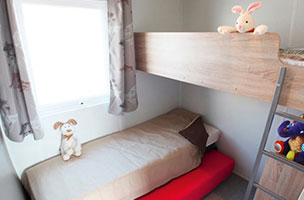 Chambre enfant avec un lit gigogne du bungalow Tithome 2 chambres 5 personnes, en location au camping à l’Abri de l’Océan dans le Finistère